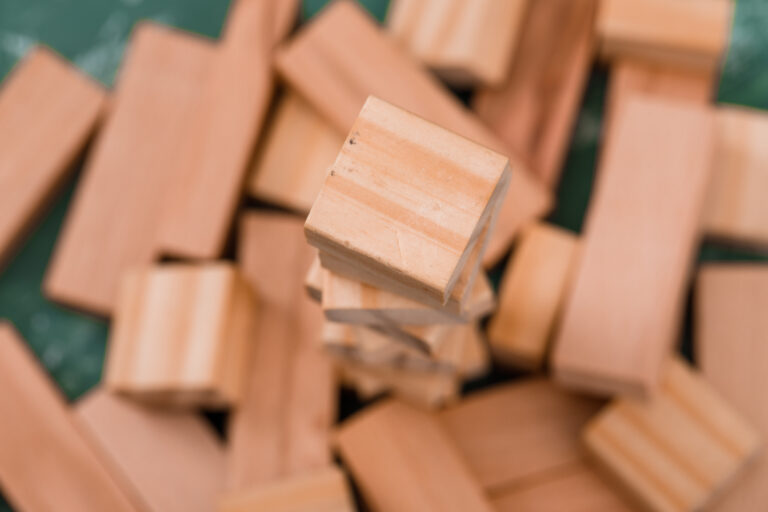 Business strategy concept with wooden block tower on plaster background close-up
